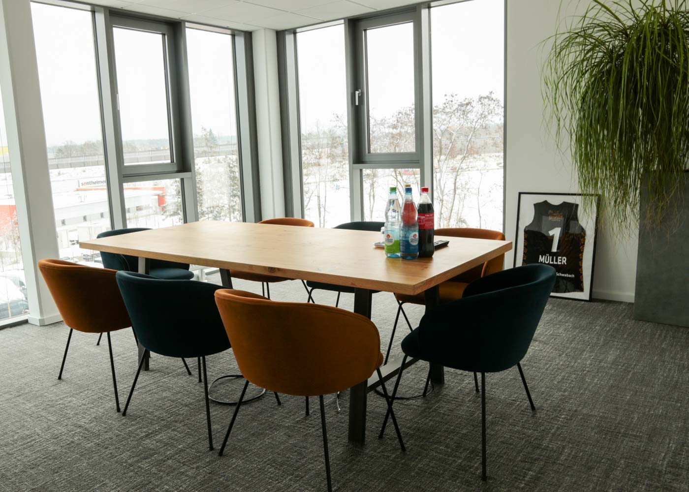 Besprechungsraum bei rankk mit großem Tisch, acht Stühlen und einer großen Fensterfront.
