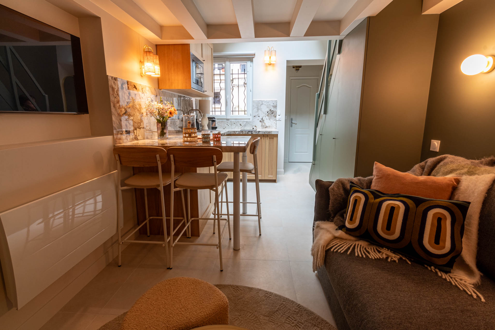 A Light theme kitchen with sunlight and chairs