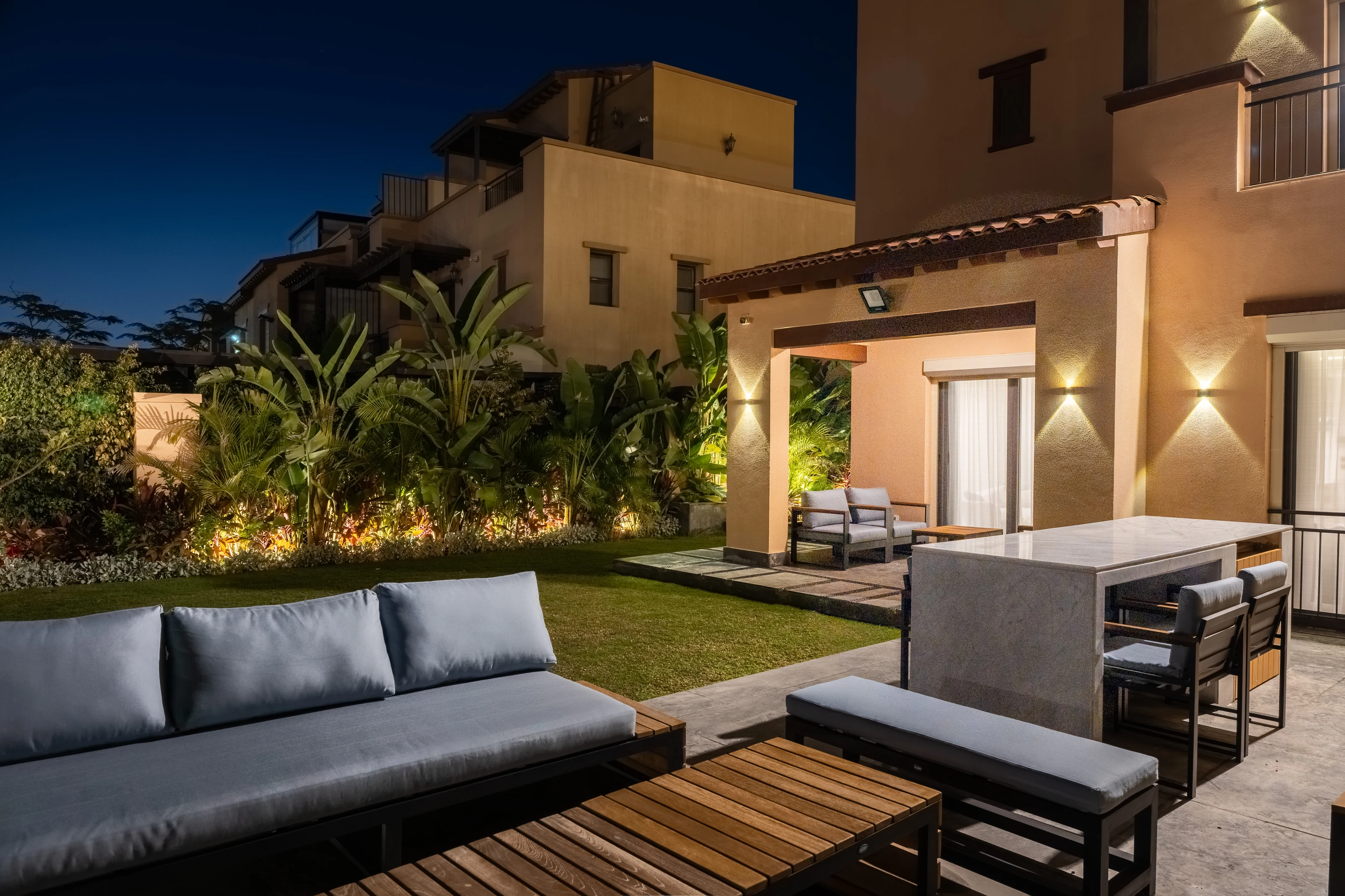 Wide night view of the Mivida Twin Villa garden and custom outdoor seating.