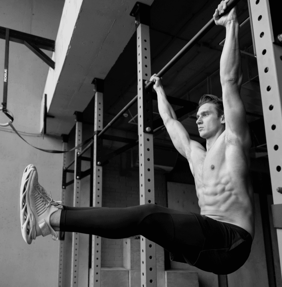 Man doing pull-ups at fitness studio
