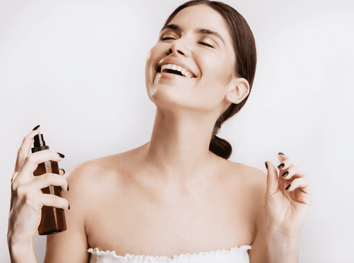 woman spraying skincare mist on face