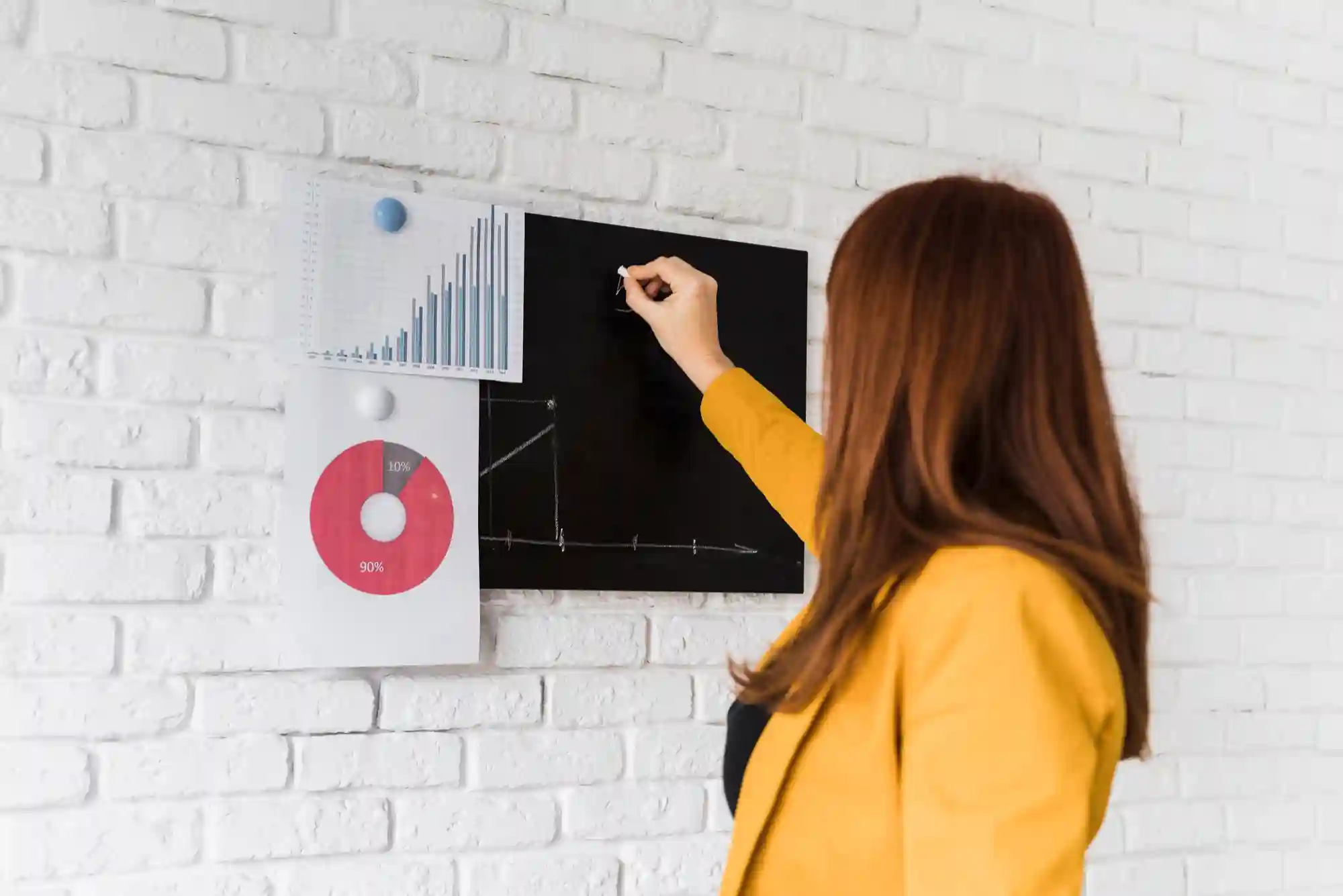 Professional presenting sales growth metrics using data visualization and a small blackboard.