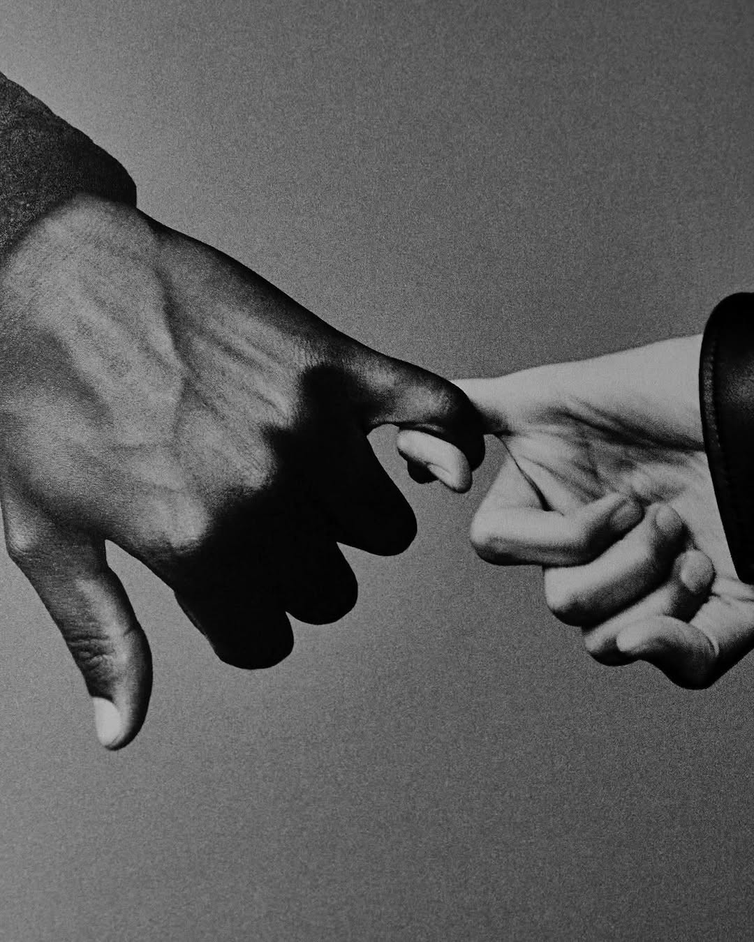 Black hand and white hand pinky promise