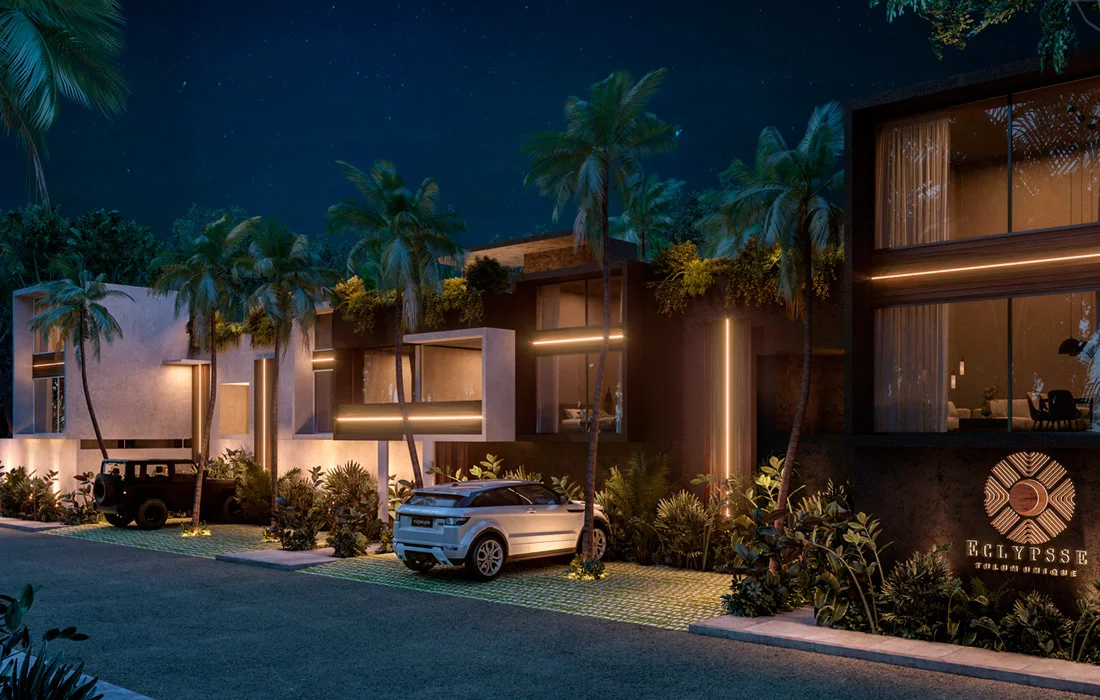 Fachada nocturna de Eclypsse Tulum Unique con iluminación LED cálida y palmeras
