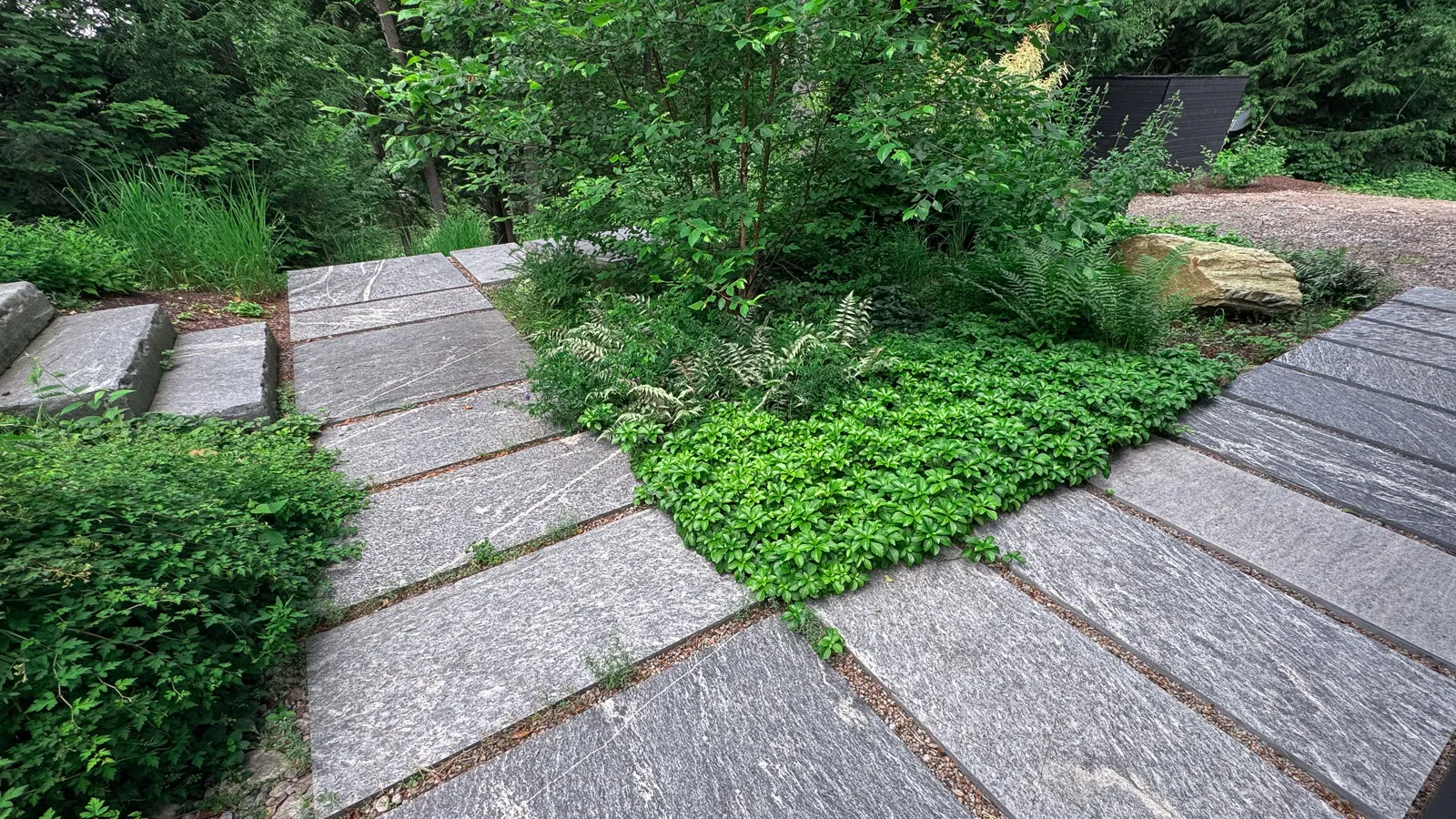 Granite stone stairway in front of mid-century modern cottage.