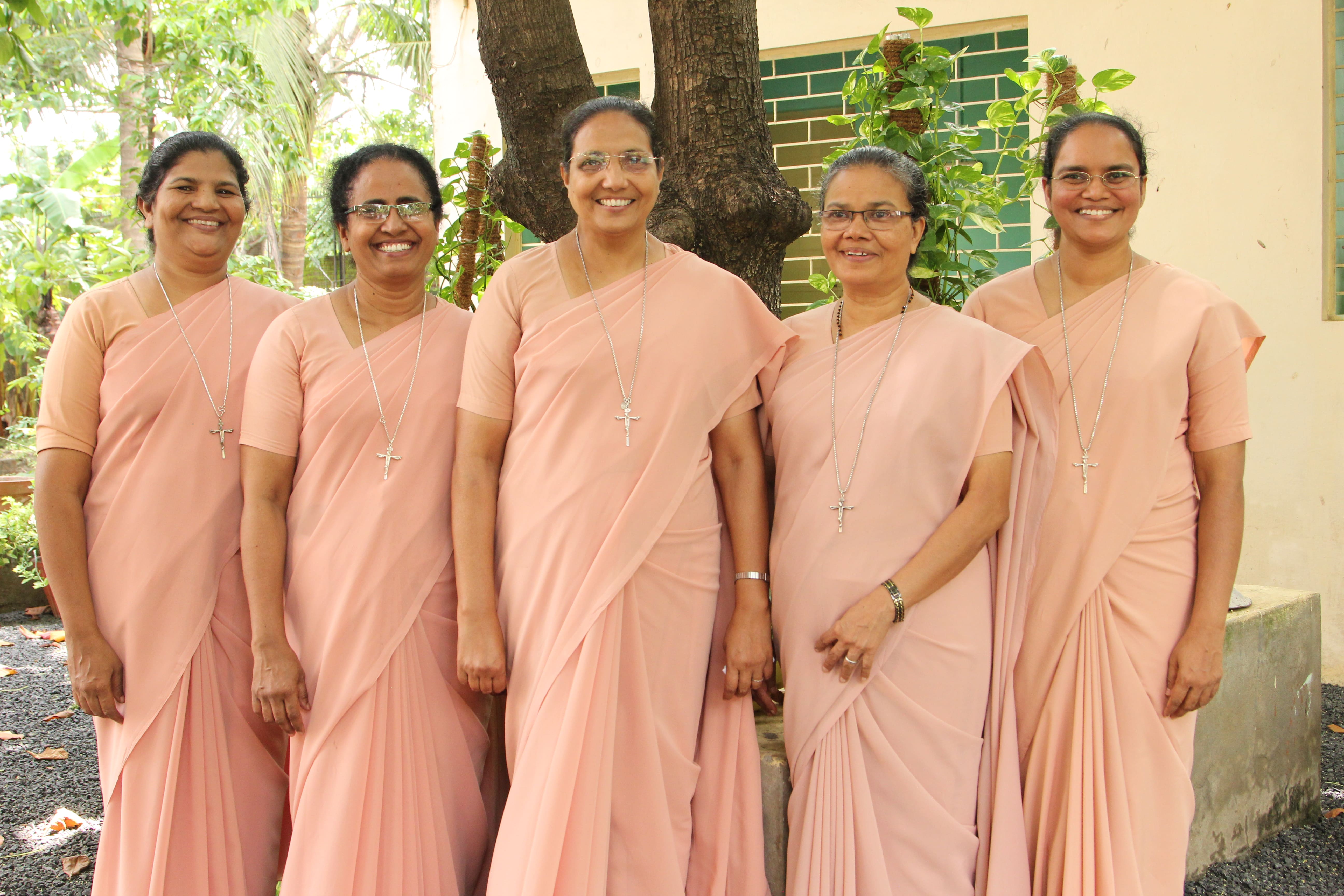 Provincial Team of the Sisters of Our Lady of the Garden, St. Mary’s Province, Indore, standing together in the garden at St. Mary's Province , Indore, Khandwa Road. From left to right: Sr. Jescy Puthenpura (Vice Provincial), Sr. Jessy Alencheril (Councillor), Sr. Grace Kadirampill (Provincial Superior), Sr. Lissy Paravil (Councillor), and Sr. Smitha (Councillor). Dressed in light pink sarees with cross necklaces, the sisters reflect unity, leadership, and the congregation’s charism of Vigilant Evangelical Charity.