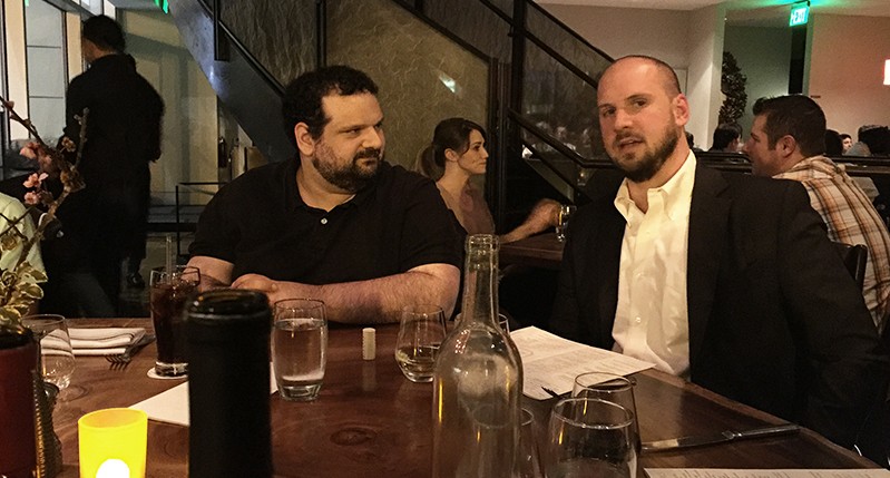 portrait of two men sitting at a table