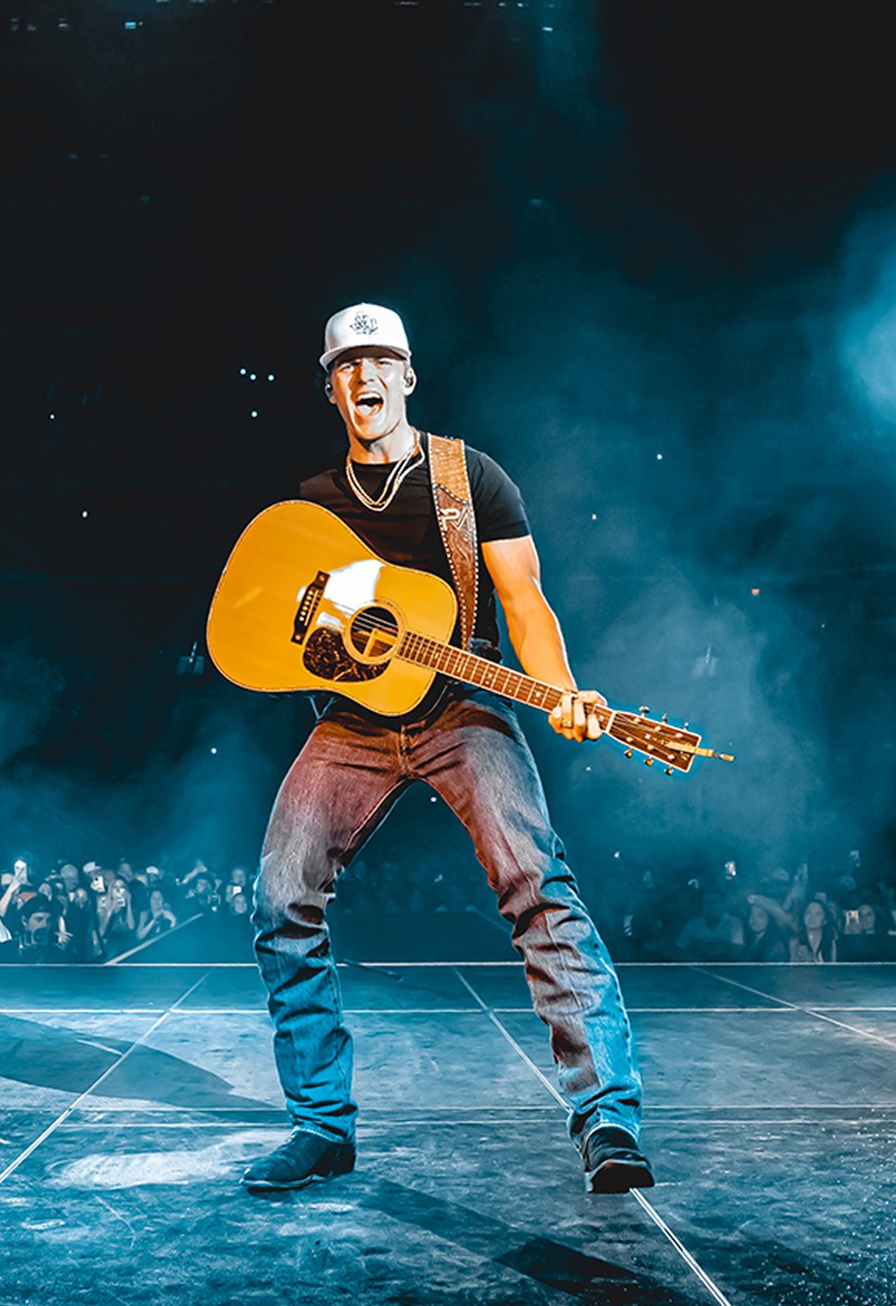 Photograph of a musician with an acoustic guitar in a live performance