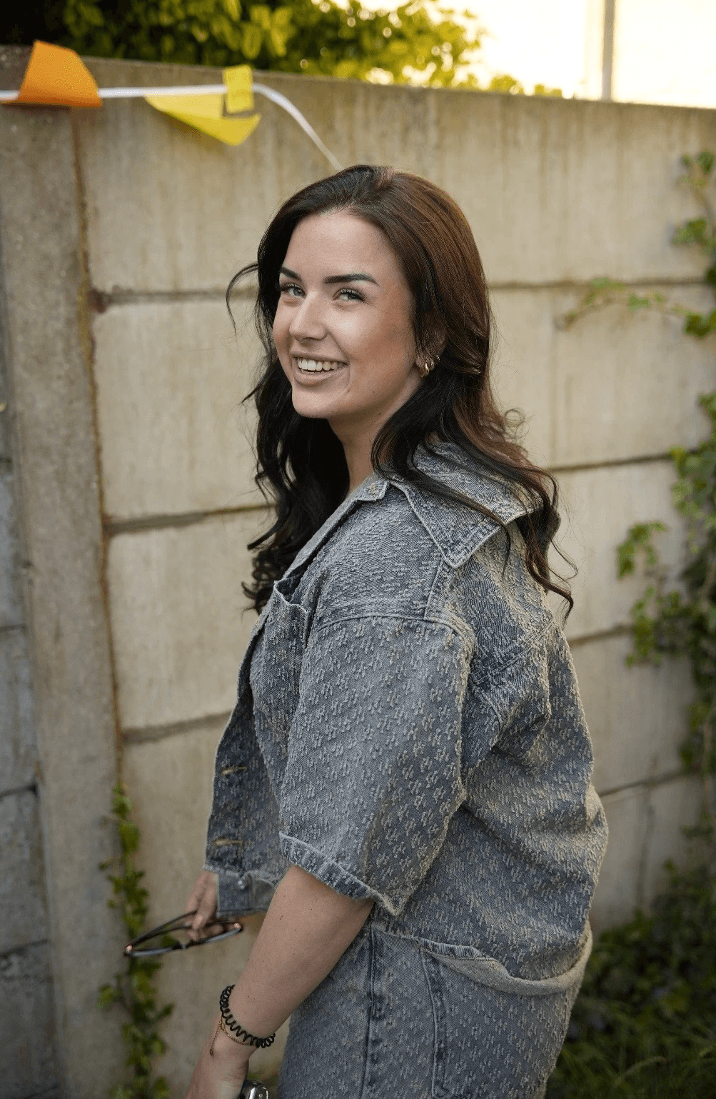 Portrait of a person in a pink sweater against a light background