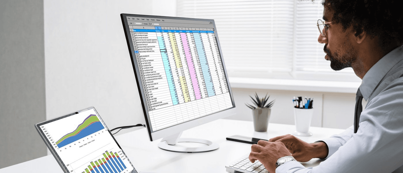 Person reviewing business data on multiple screens - Best Excel Course for Financial Analyst