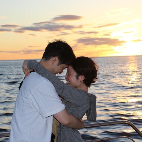 Kaksi iloista vierasta nauttimassa auringonlaskusta