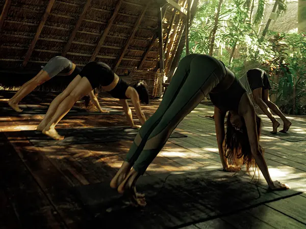 Clase de yoga matutina en la playa en Nomade Tulum, México