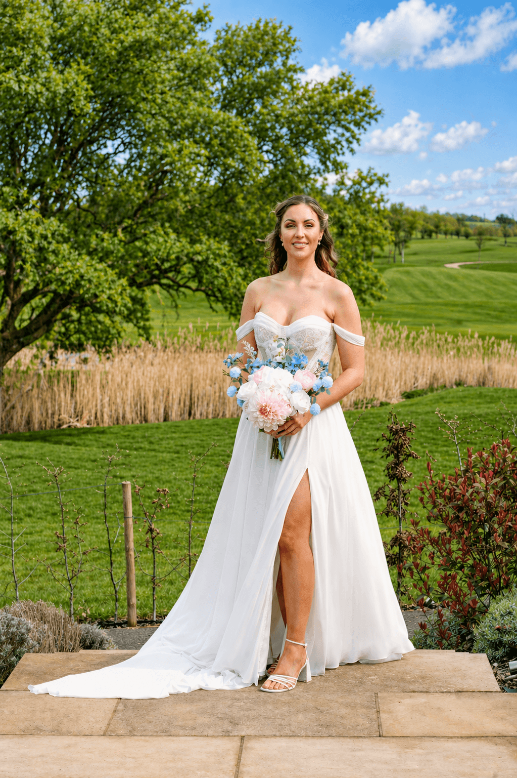 A bride in a white lace wedding dress holds a colorful bouquet of pink, yellow, and orange flowers.