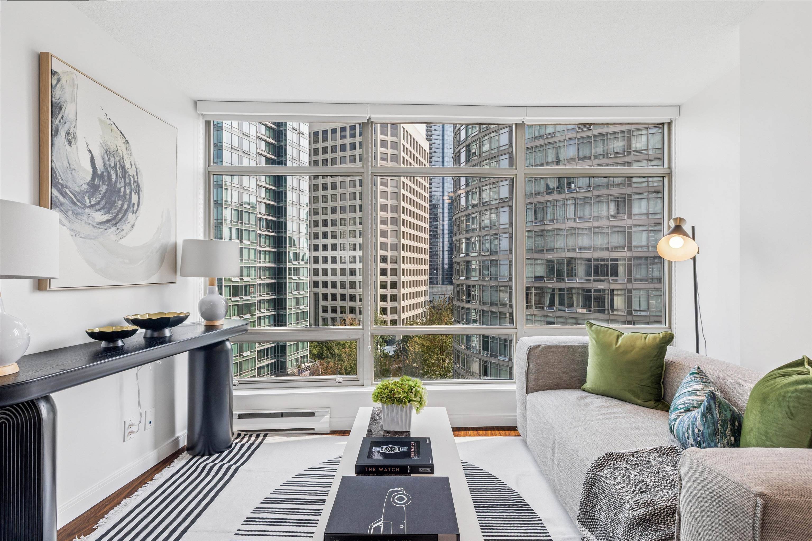 Modern living room with large windows, contemporary furniture, and urban views. Bright and airy space.