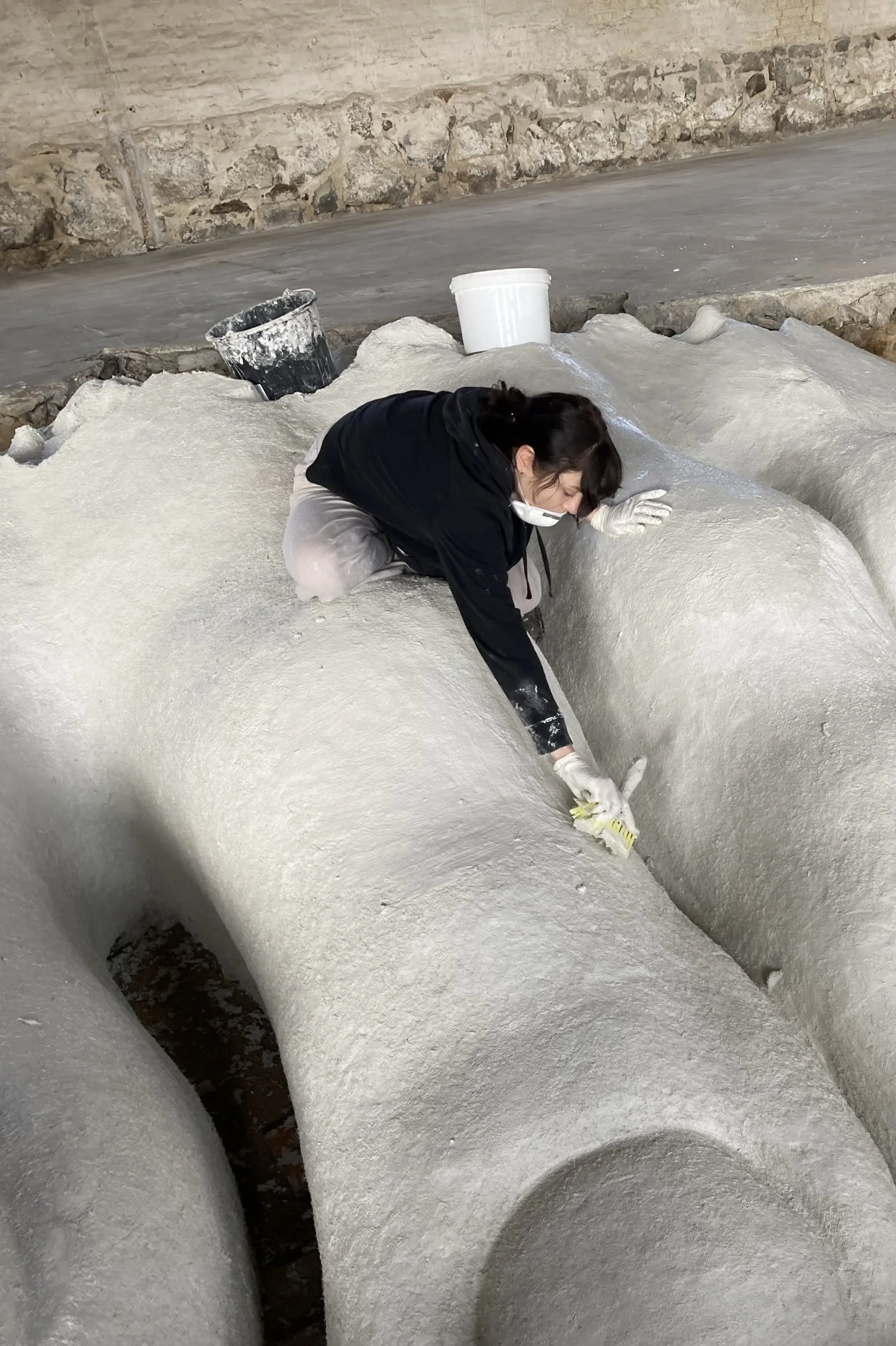 Artist assistant Zuzanna Kozłowska working with the concrete construction of EarthdrivE - A part. 