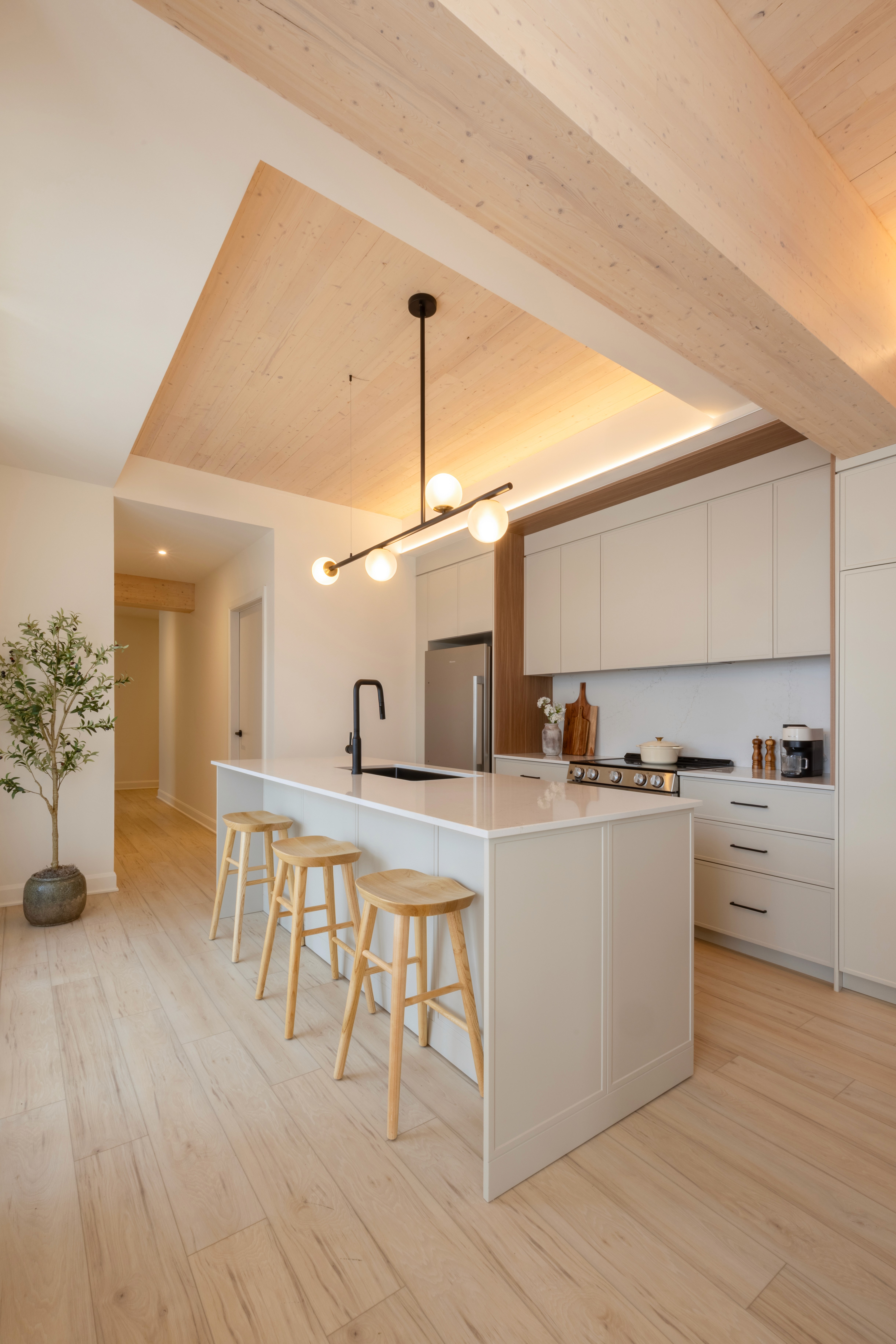 "Cuisine contemporaine avec îlot central, finitions en bois naturel et quartz – Projet locatif à Lachine.