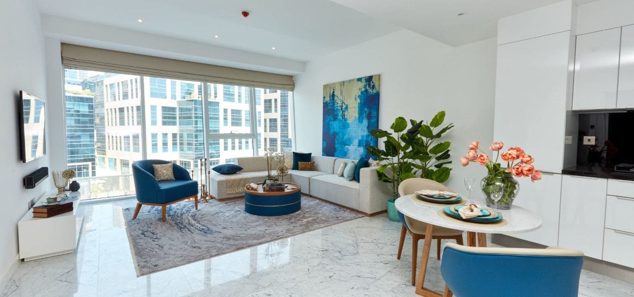  A modern apartment featuring a spacious living room and kitchen, designed by The Pad by OMNIYAT.