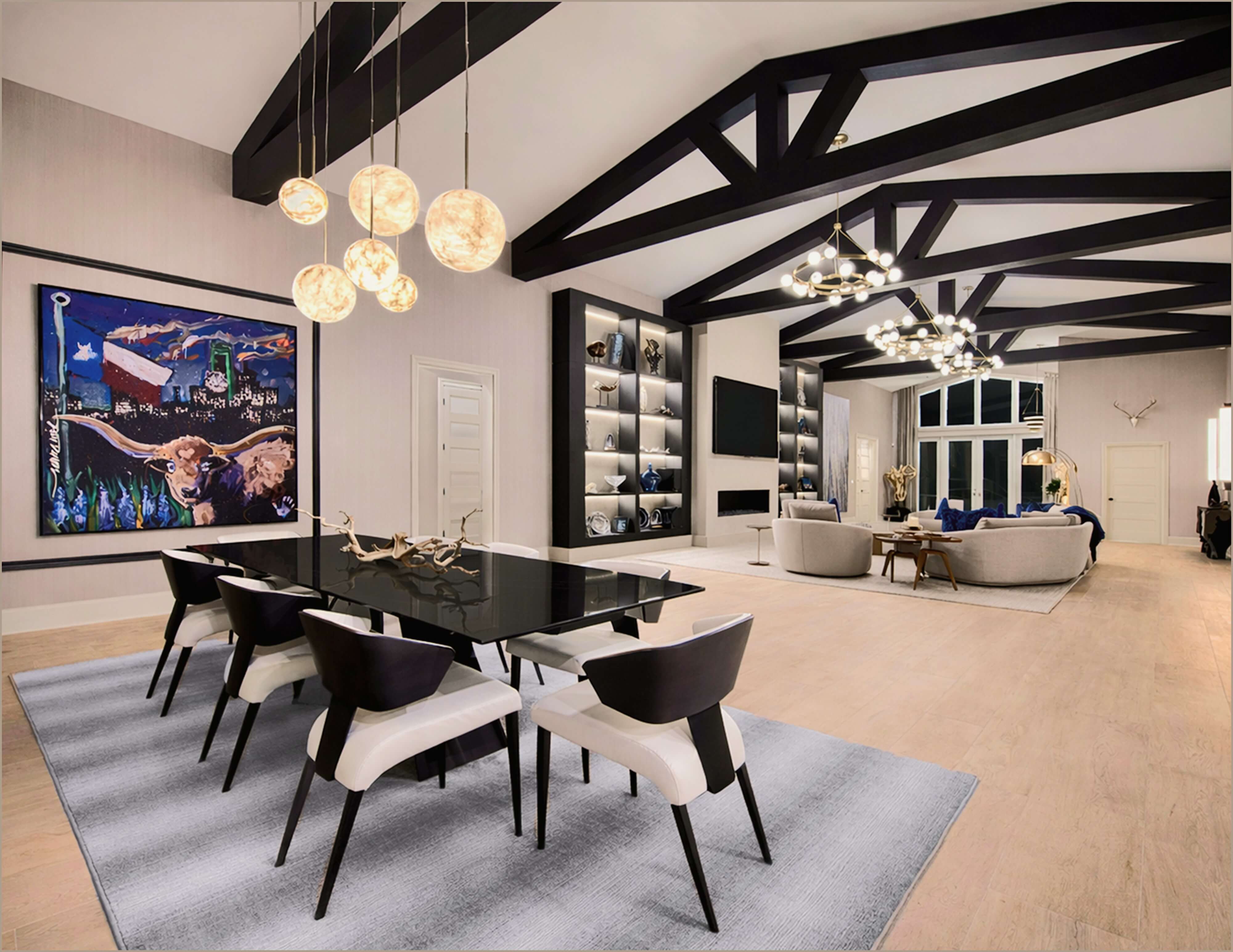 Elegant living room with white sectional, dark built-ins, brass chandelier, and framed abstract art.