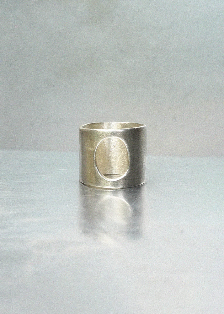 Silver ring with a circular cutout on a light gray background