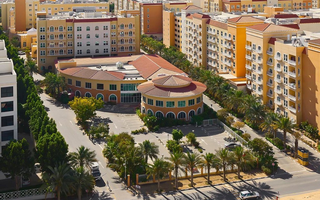 Panoramic image of Dubai Investment Park featuring commercial and residential areas surrounded by lush landscaping.