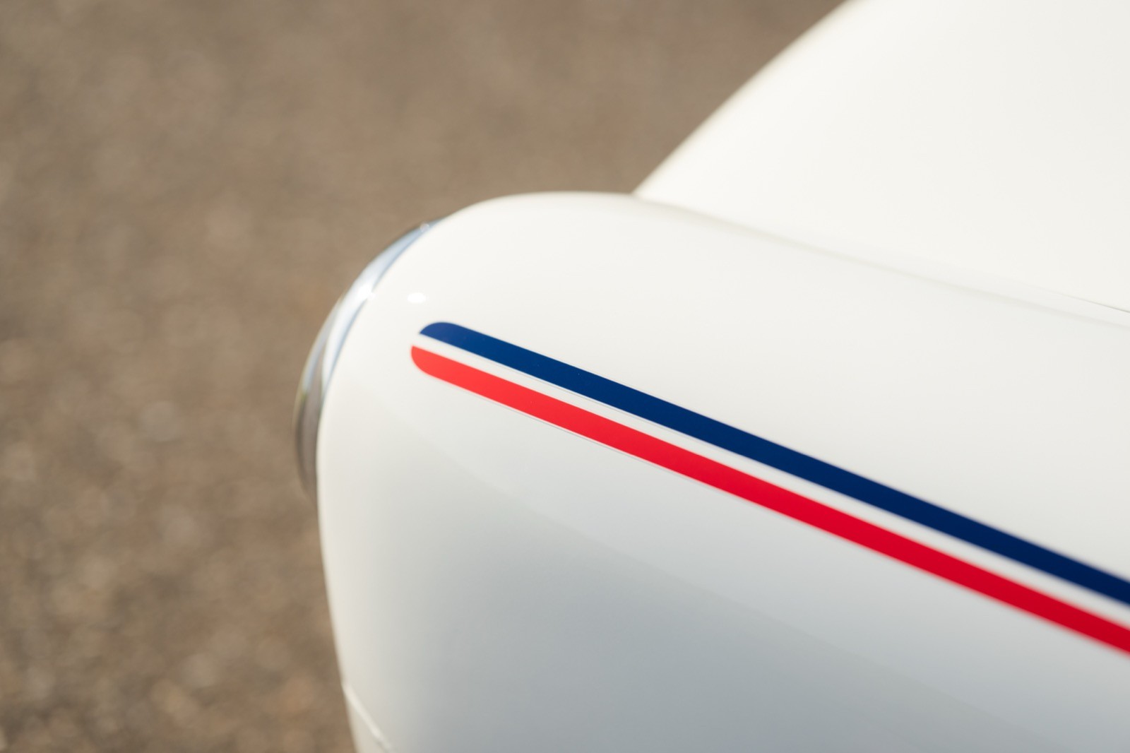 Close-up of a white surface with a red and blue stripe along the edge, set against a textured background.