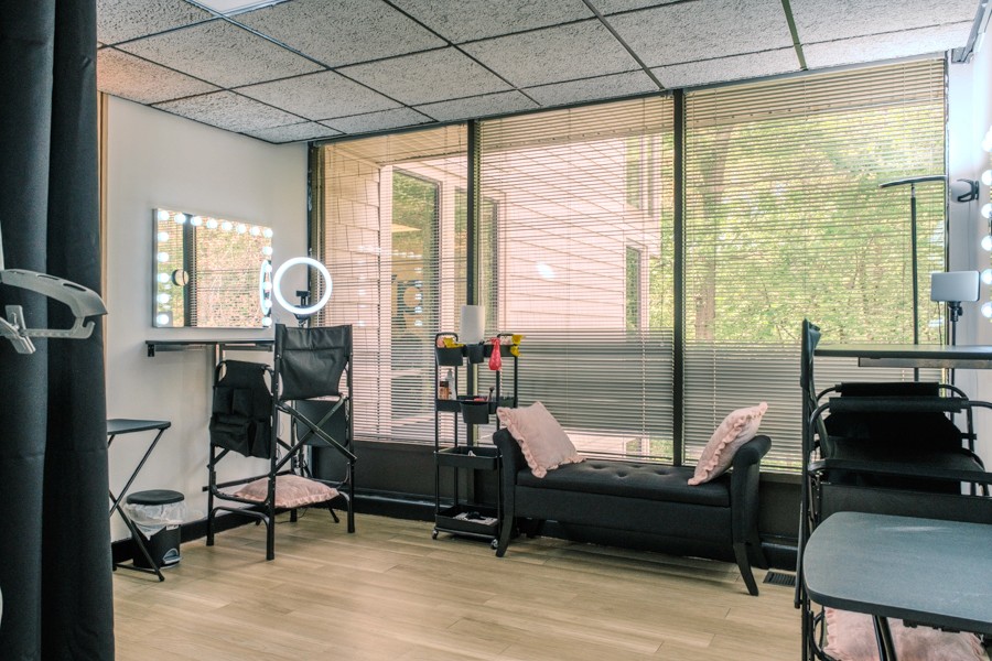Beauty room prep area with ring light, seating, and large windows