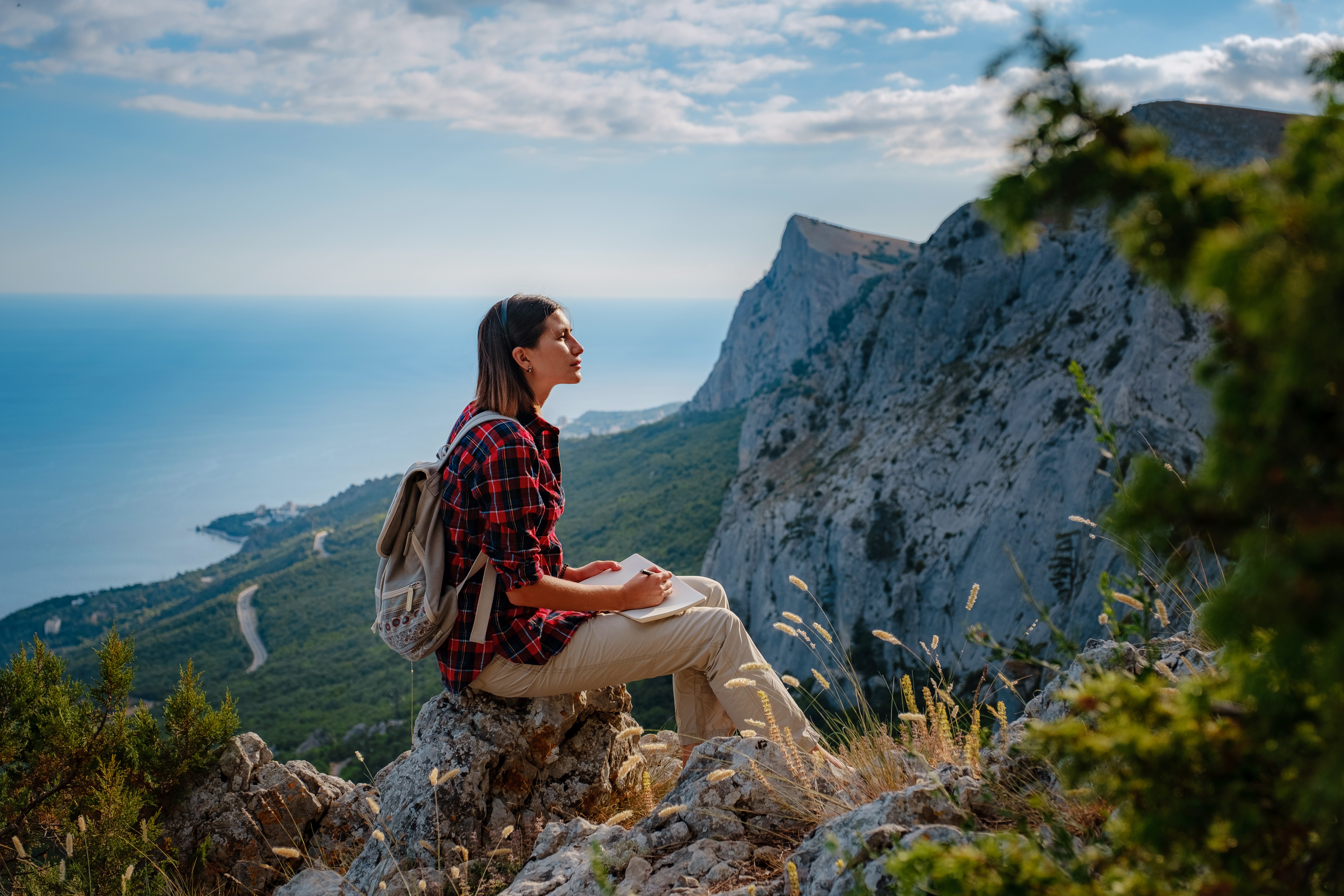 Woman hiker enjoys the view at mountain peak