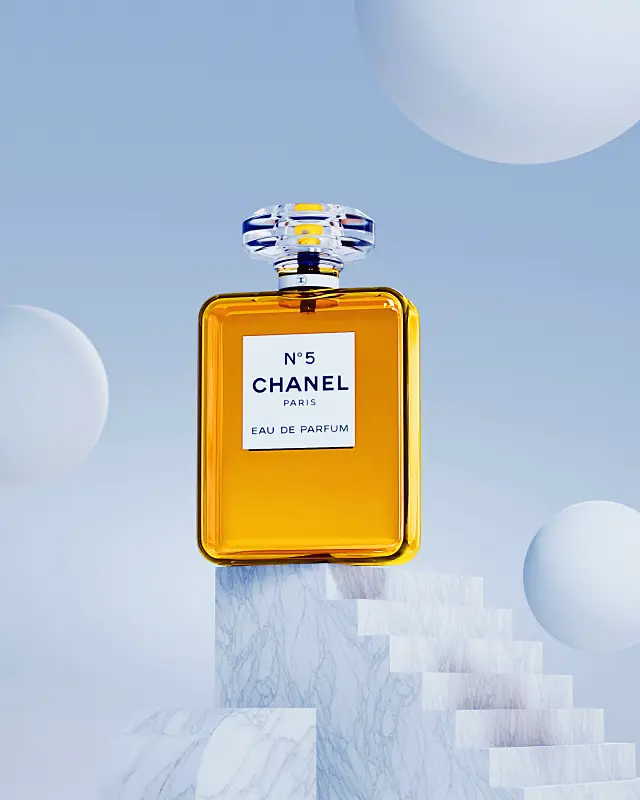 A bottle of Chanel N°5 Eau de Parfum sits elegantly on a white marble pedestal against a serene blue background with floating spheres, highlighting its iconic design and luxury fragrance.