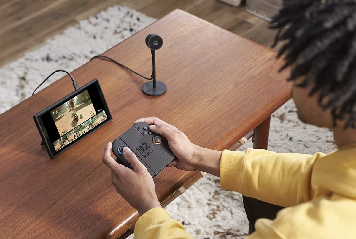 Person holding controller looking at portable game console