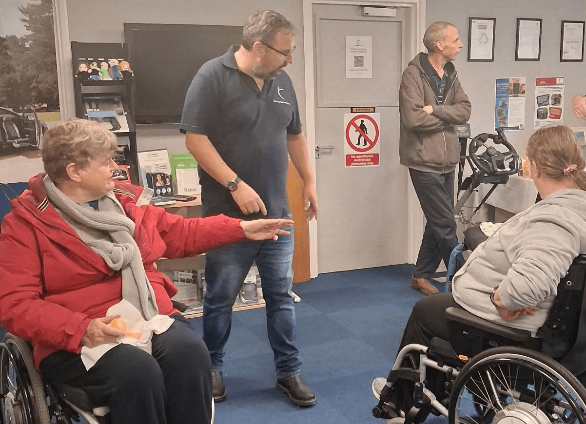 Group of staff and visitors looking at wheelchairs during our SD Motion coffee morning