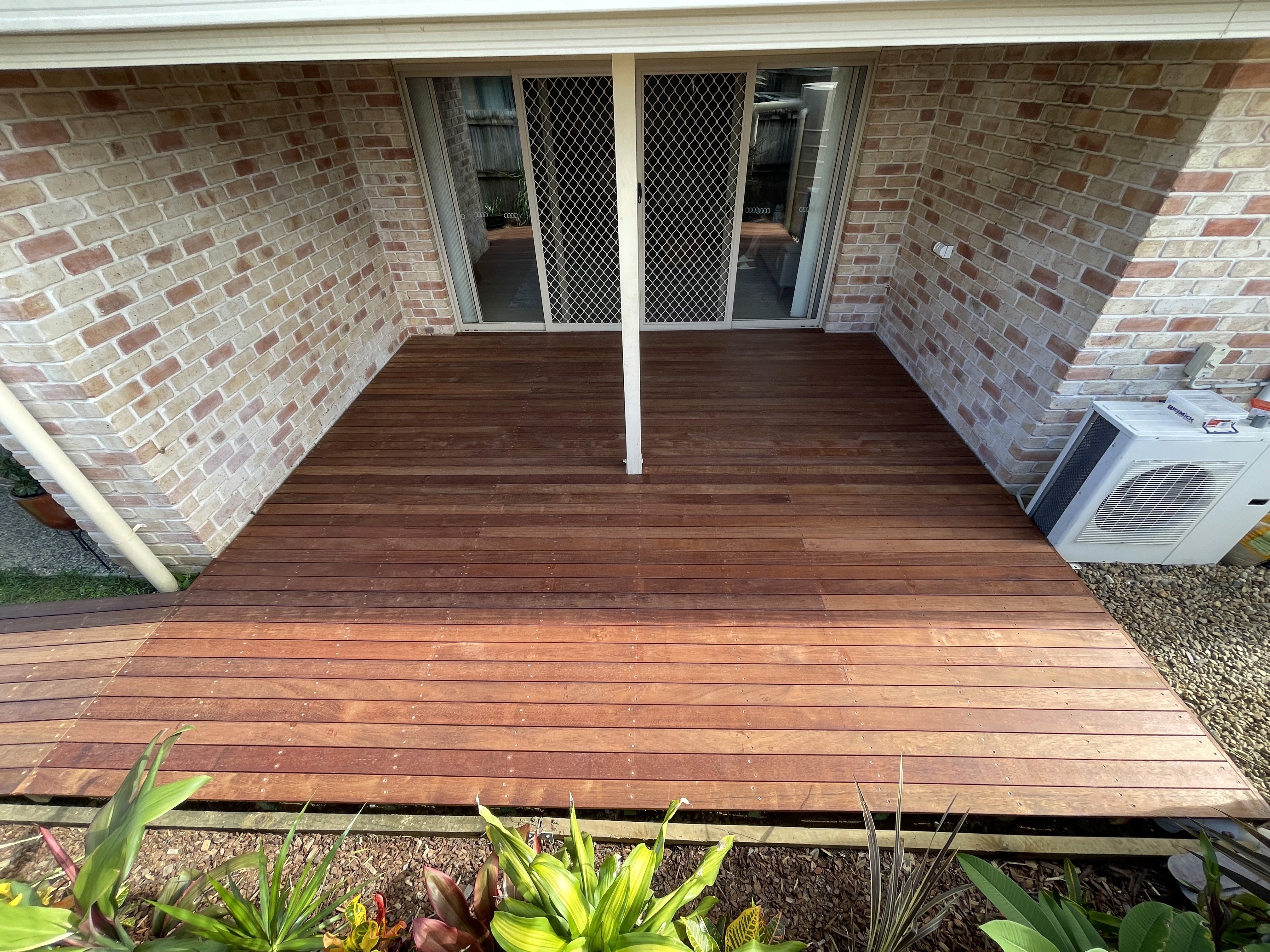 A man and a woman in casual clothing stand face-to-face in a photography studio with a white backdrop. Both have a neutral expression as they engage in conversation.