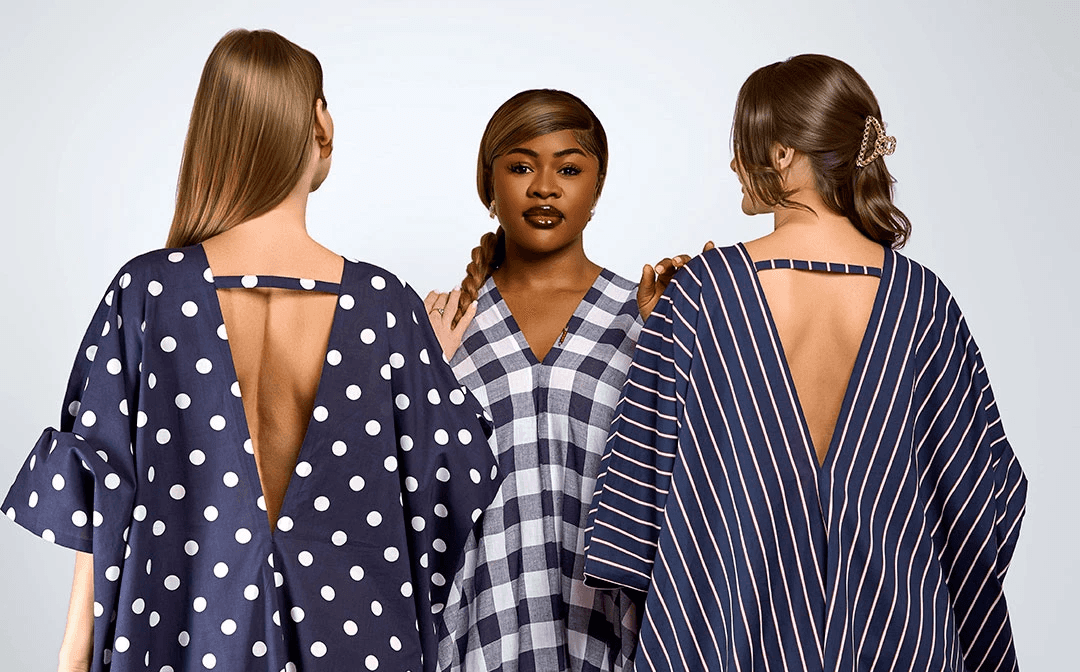 Three models standing in a wheat field, wearing beige suits.