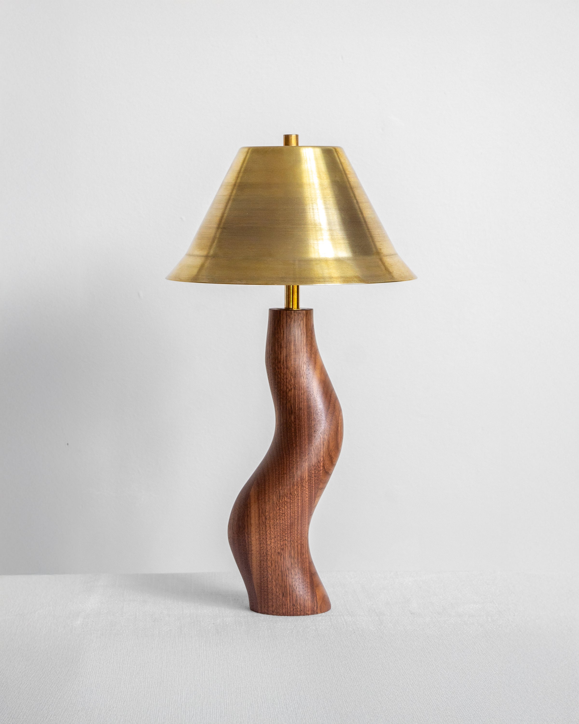 Dancing Desk Lamp with Walnut base and Brass shade on a light grey background with UK, EU and US/CA wiring available Wilkinson & Rivera