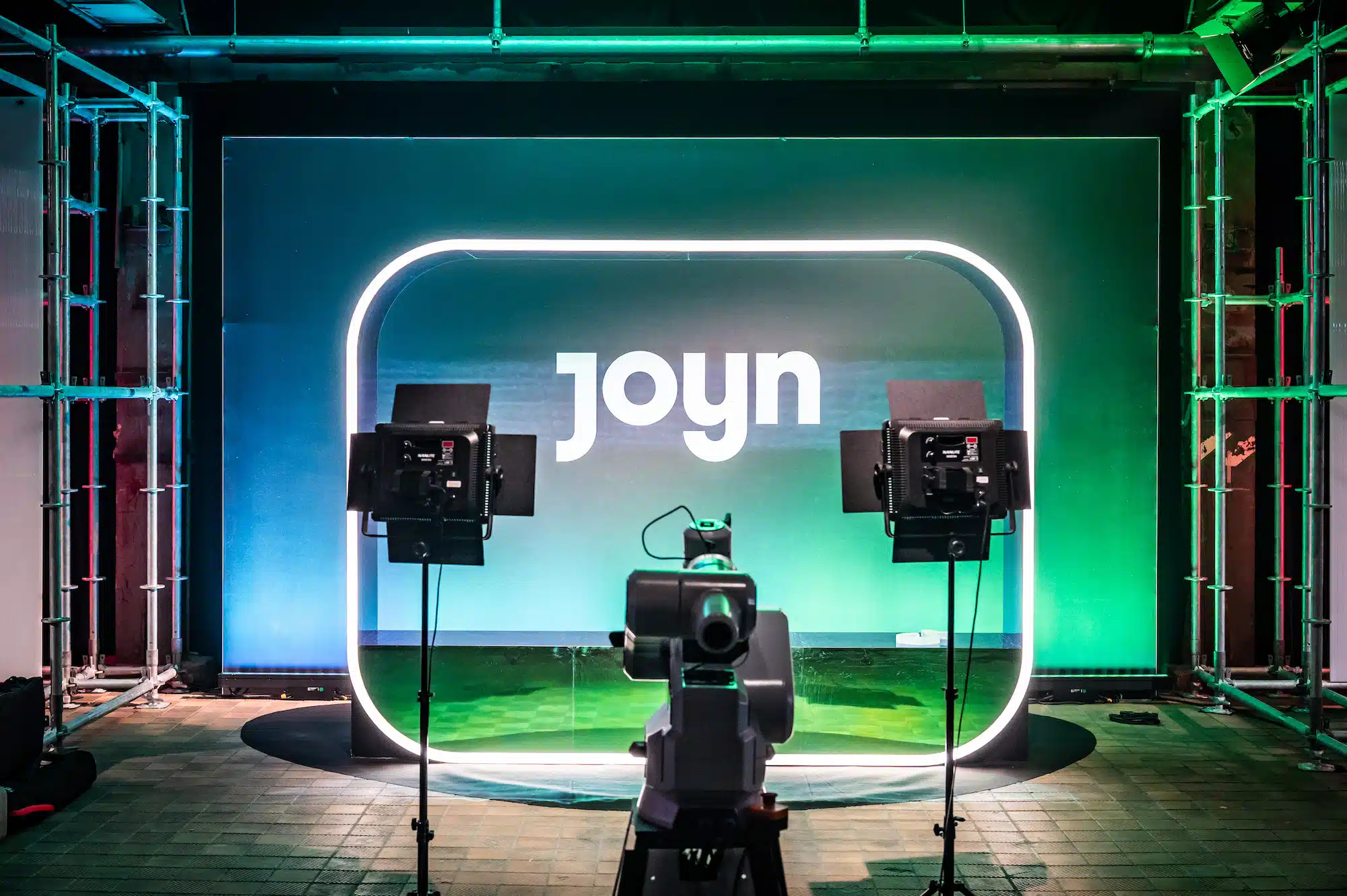 TikTok Awards – car activation with dramatic fog staging and illuminated neon aJoyn Streaming – activation studio with glowing Joyn logo neon background in green, camera setup and industrial ambiancert installations