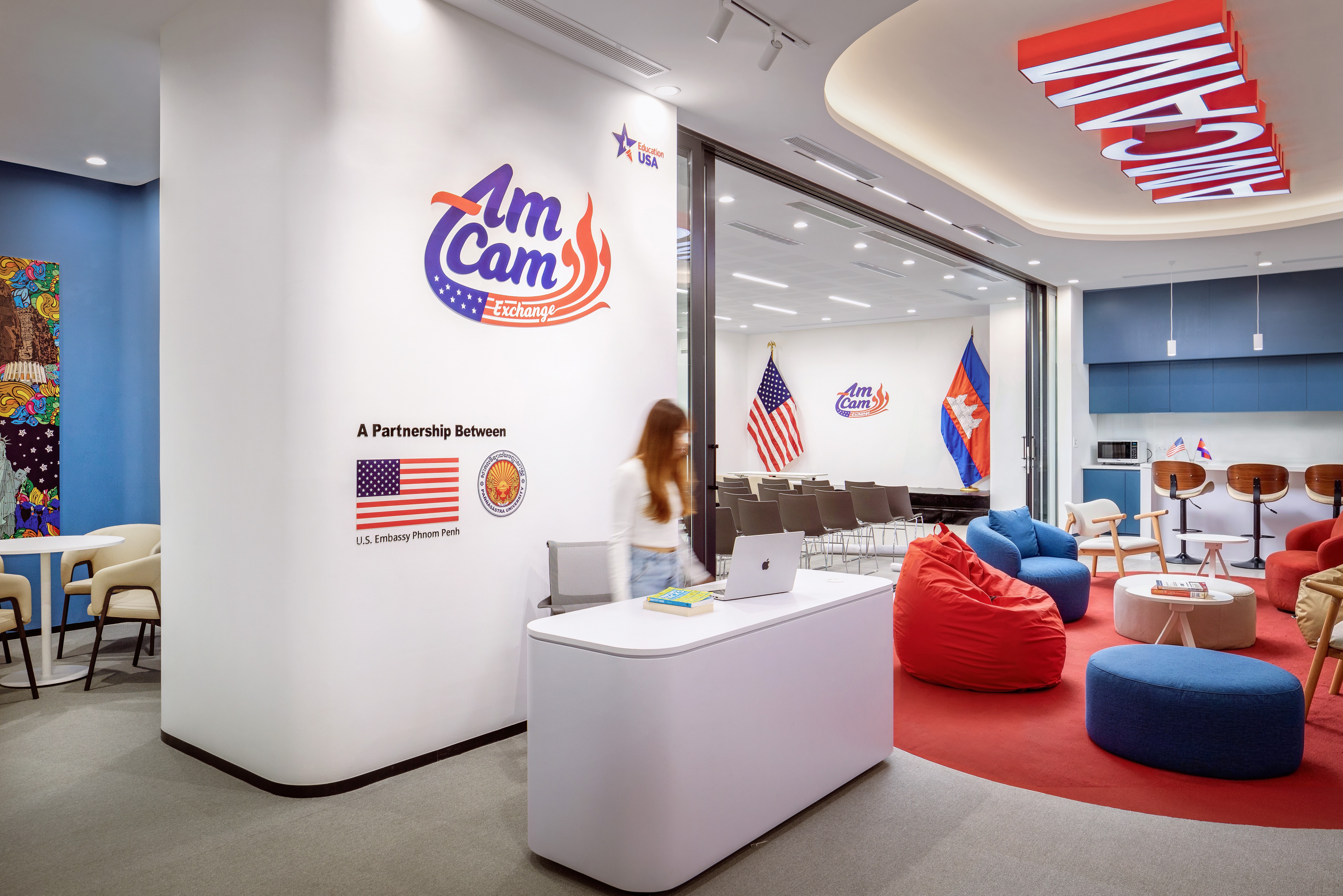 Reception area at AmCam Exchange Phnom Penh featuring U.S. Embassy branding and strategic counseling zone.