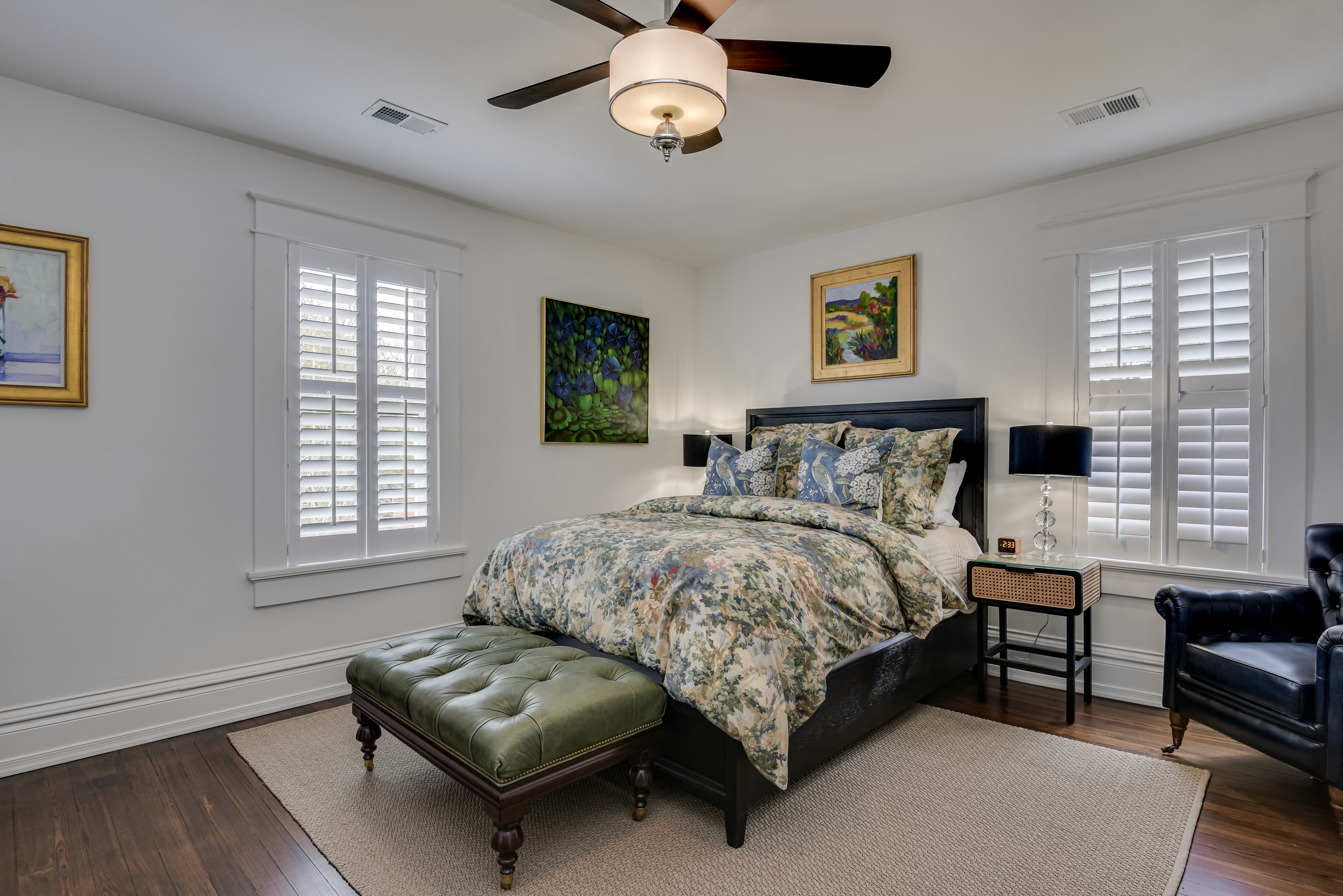 Generously sized bedroom featuring a queen-size bed and a dedicated workspace.
