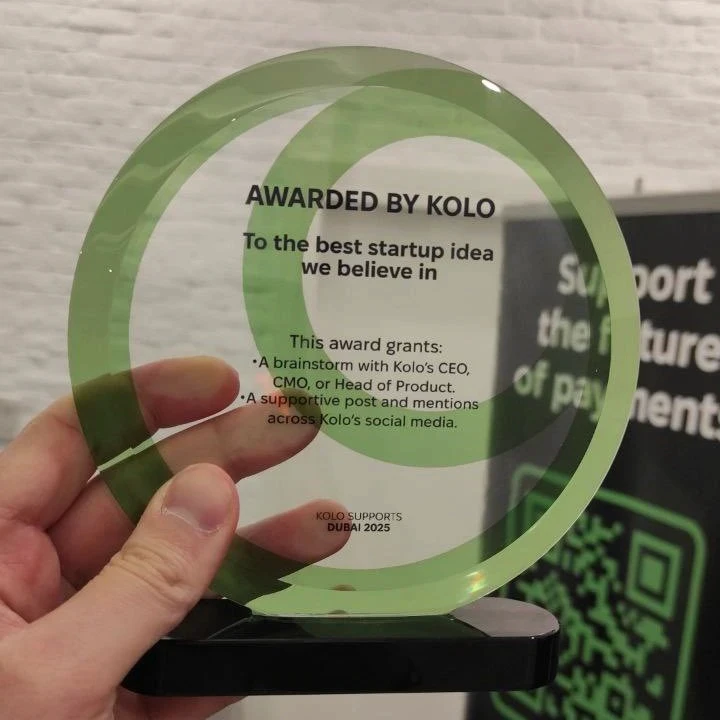 Kolo Award for Best Startup Idea. Clear trophy held in hand.