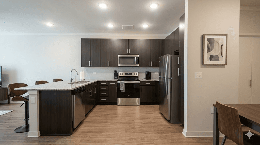 Apartment kitchen with dark wood cabinets, granite countertops, and stainless steel appliances at The Reserve at Cool Springs, Elizabethtown, KY