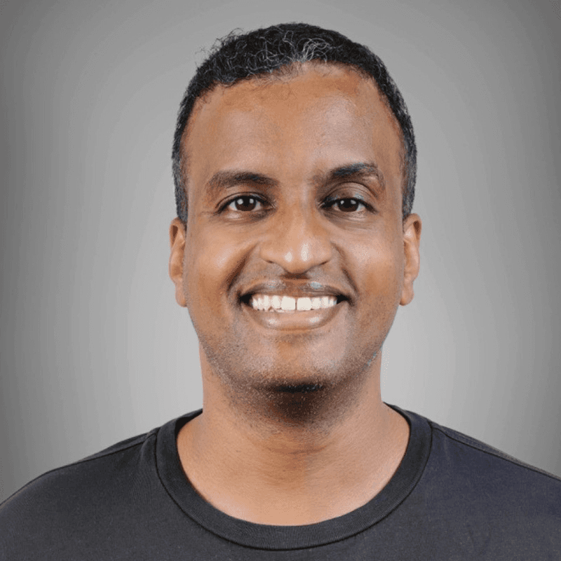 Smiling man using a laptop in warm indoor light