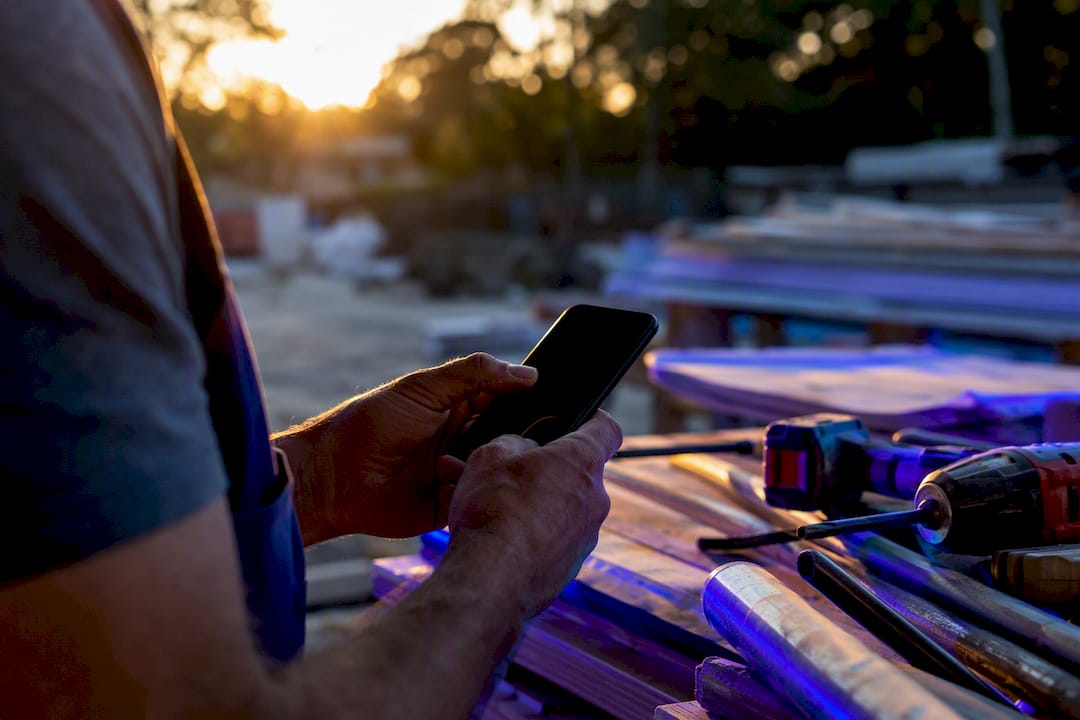 Contractor reviewing service request on phone