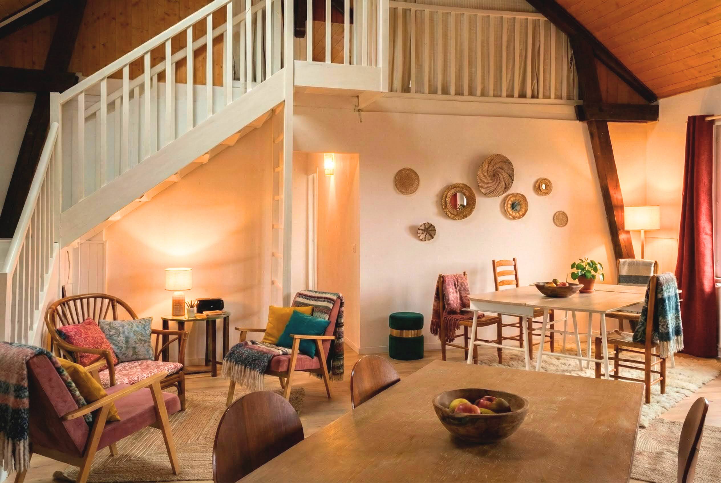 une salle de travail accueillante et chaleureuse, équipée de plusieurs tables et chaises.