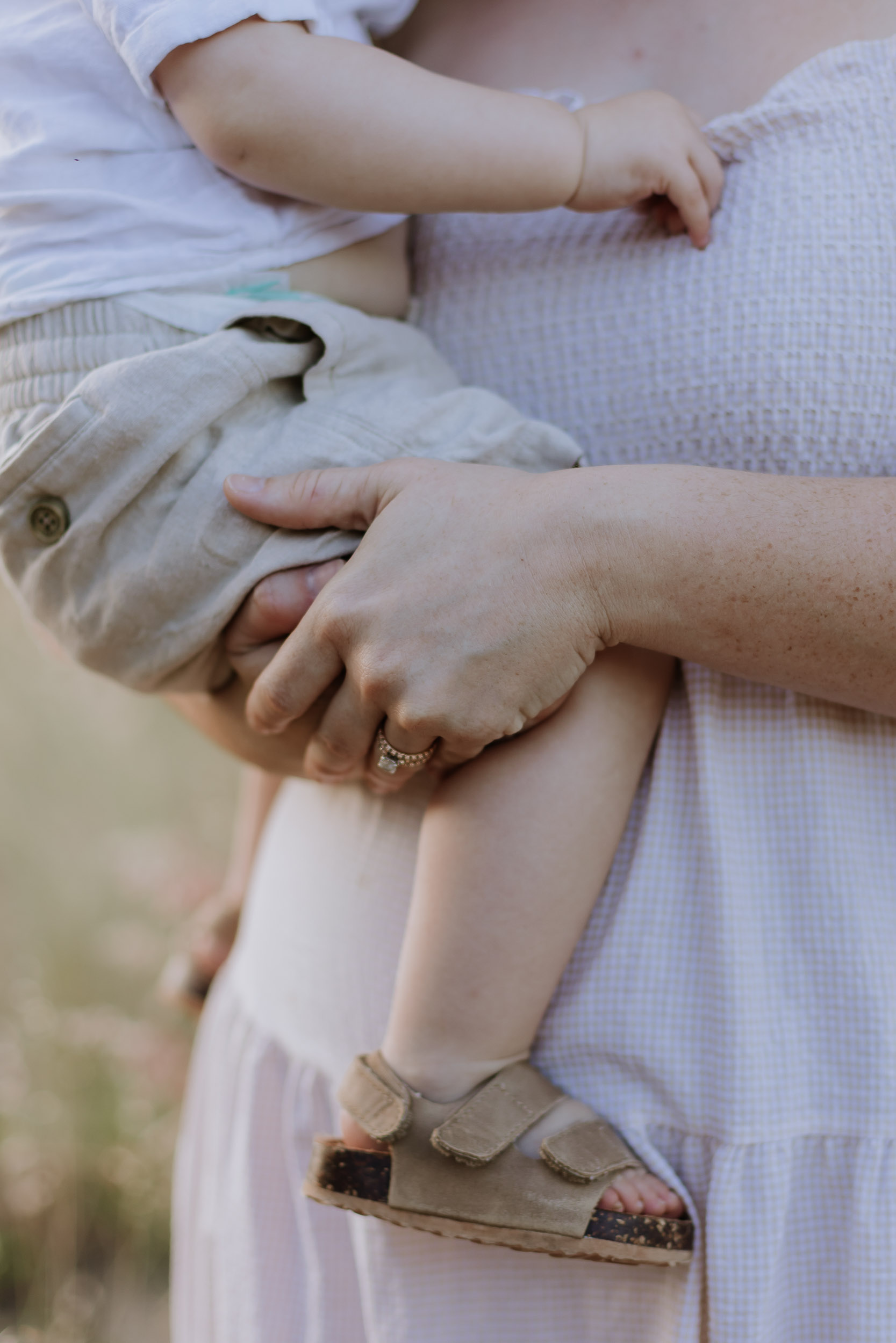 Mother holding child in long grass outdoor photoshoot Mackay