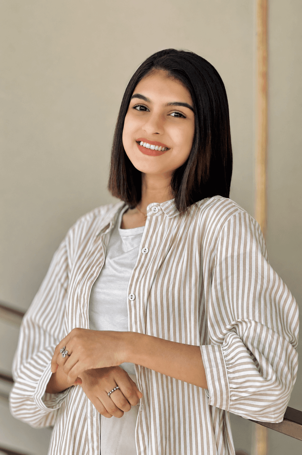 A smiling young woman with a sharp, sleek medium-length haircut and professional styling at The Beauty Lounge by DULHAN.