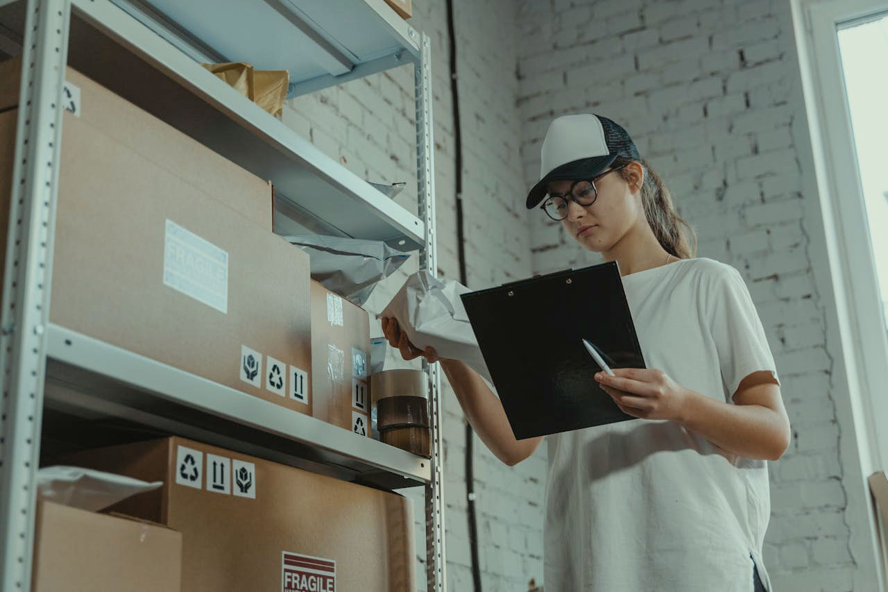 A female worker making inventory in a warehouse.