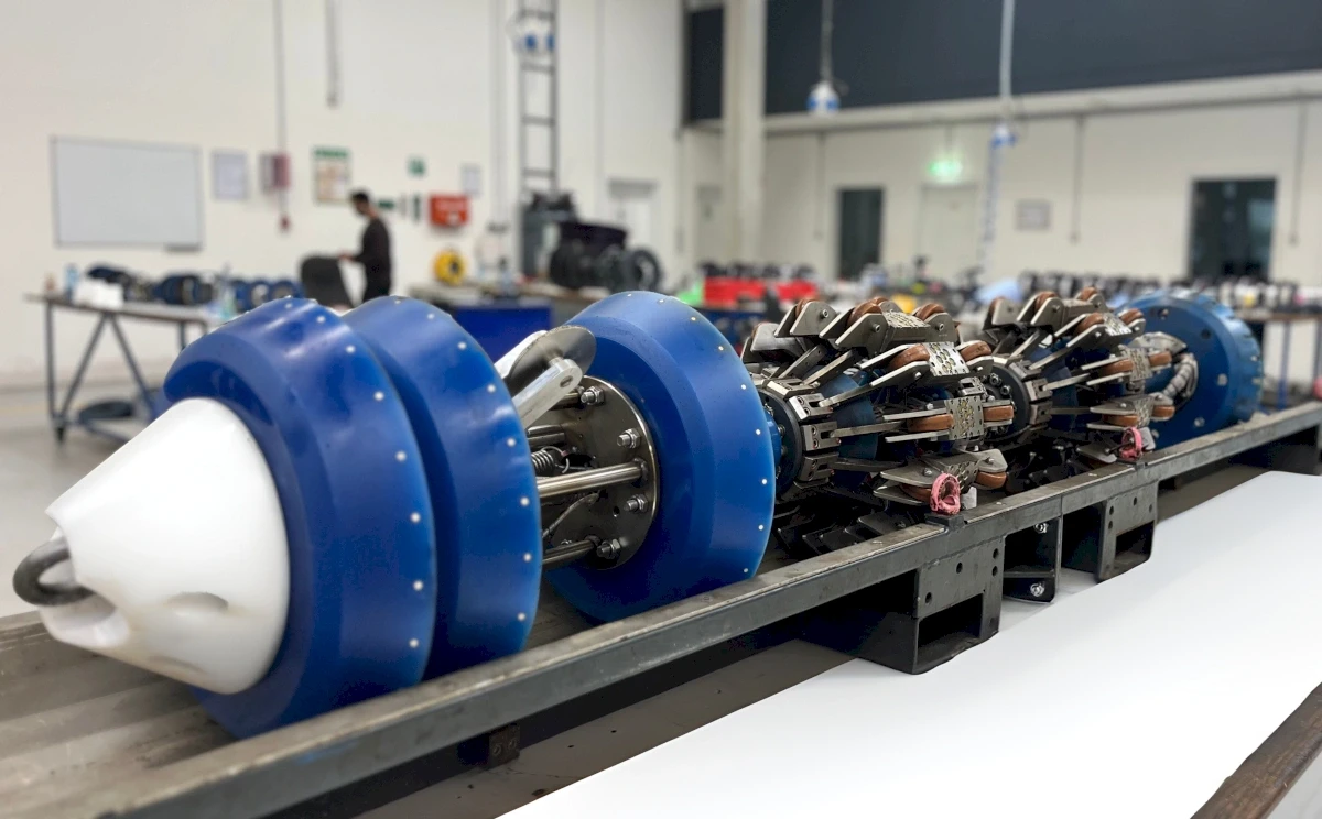 Ein Rohrinspektionsgerät. Es ist blau, weiß und silbern. Im Hintergrund ist eine Person bei der Arbeit zu sehen.