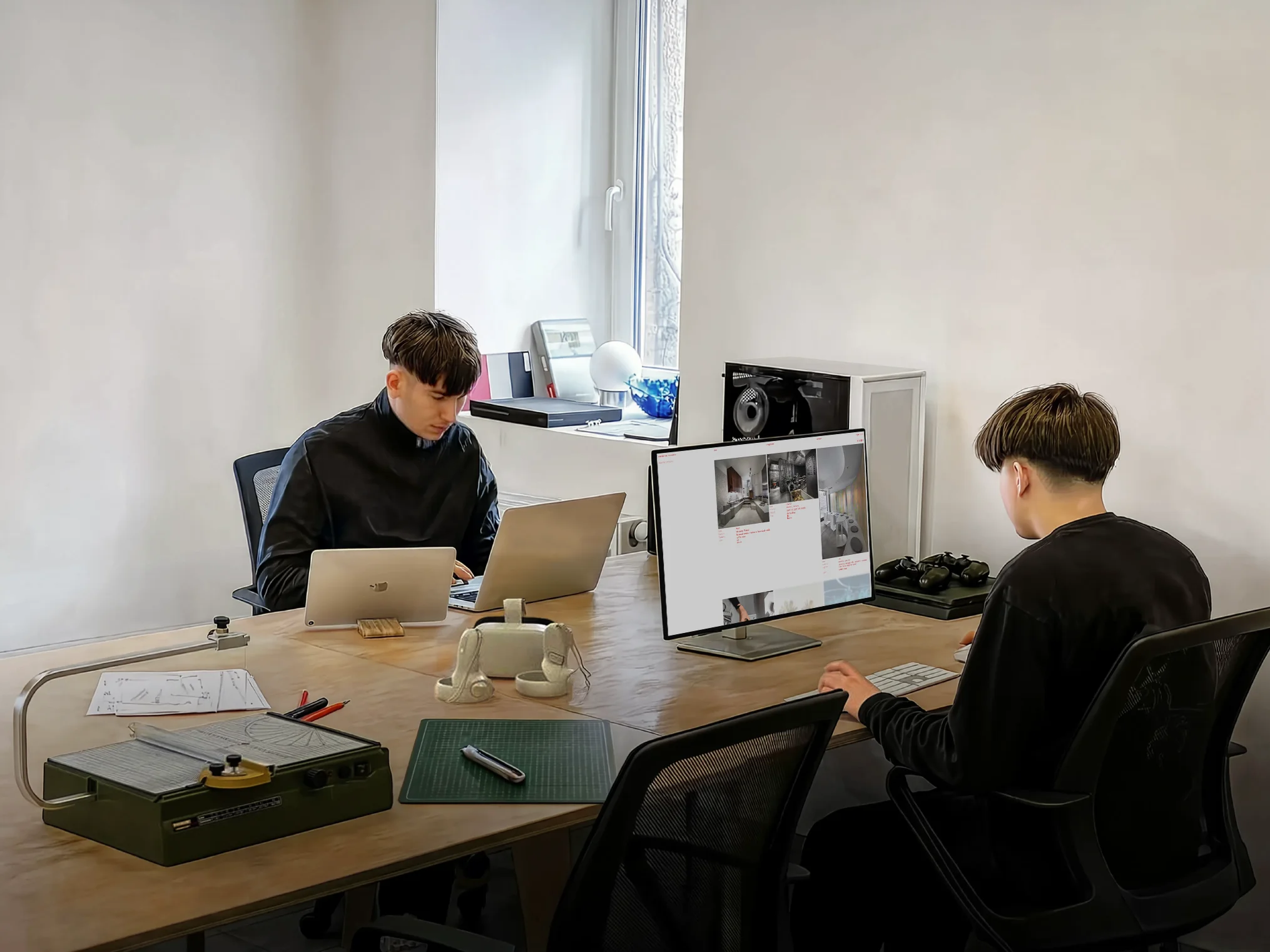 "A working moment from my office, with new projects open on laptops and the main monitor. The table mixes digital work with paper, tools, and small physical details of the design process."