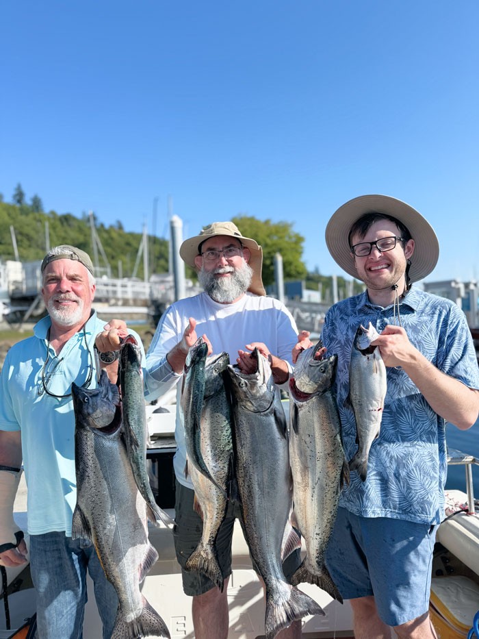 Family holding big salmon on Puget Sound Seattle charter boat.