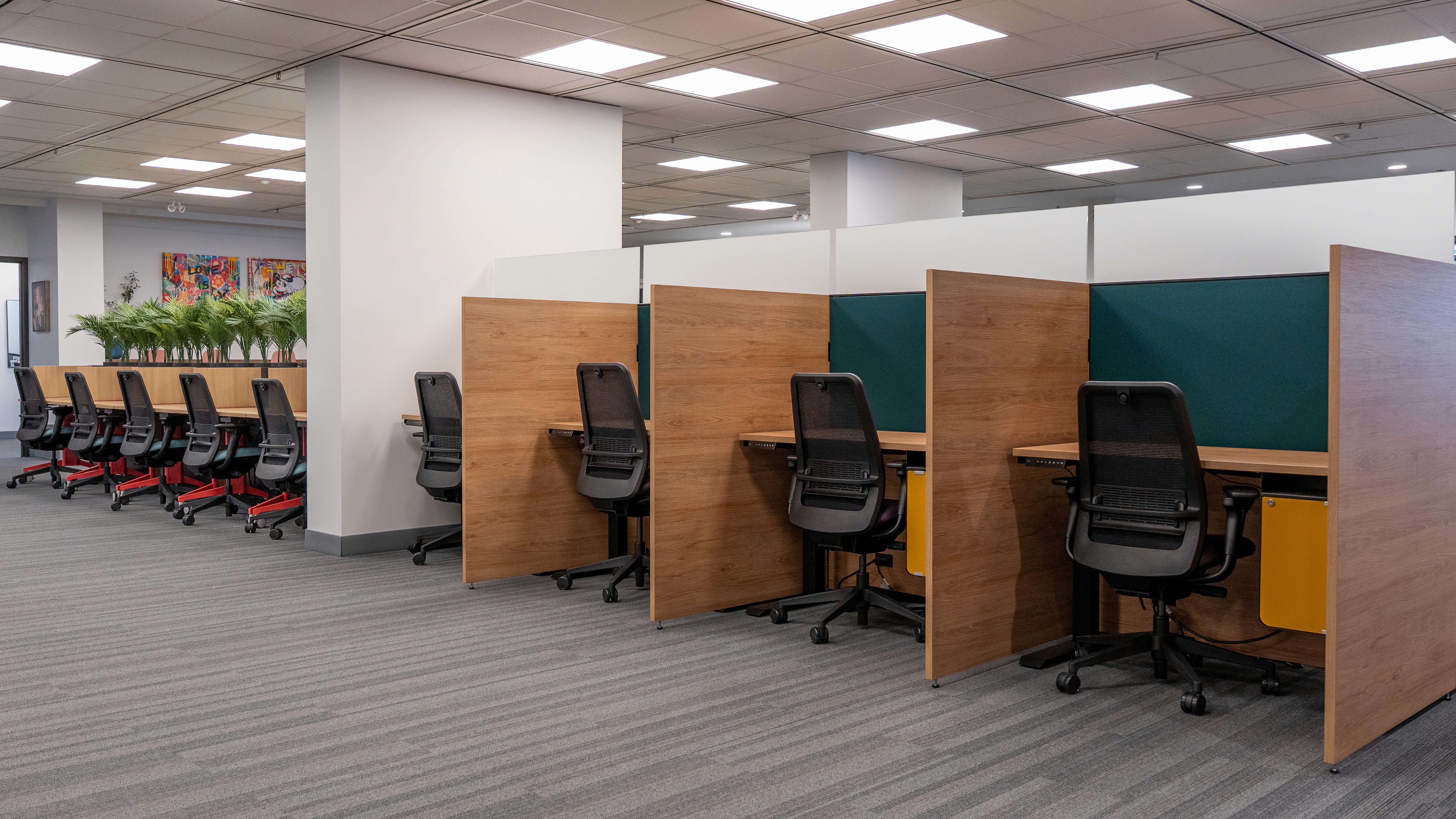 Modern design studio with large windows, work tables, and bold graphic posters displayed on the walls