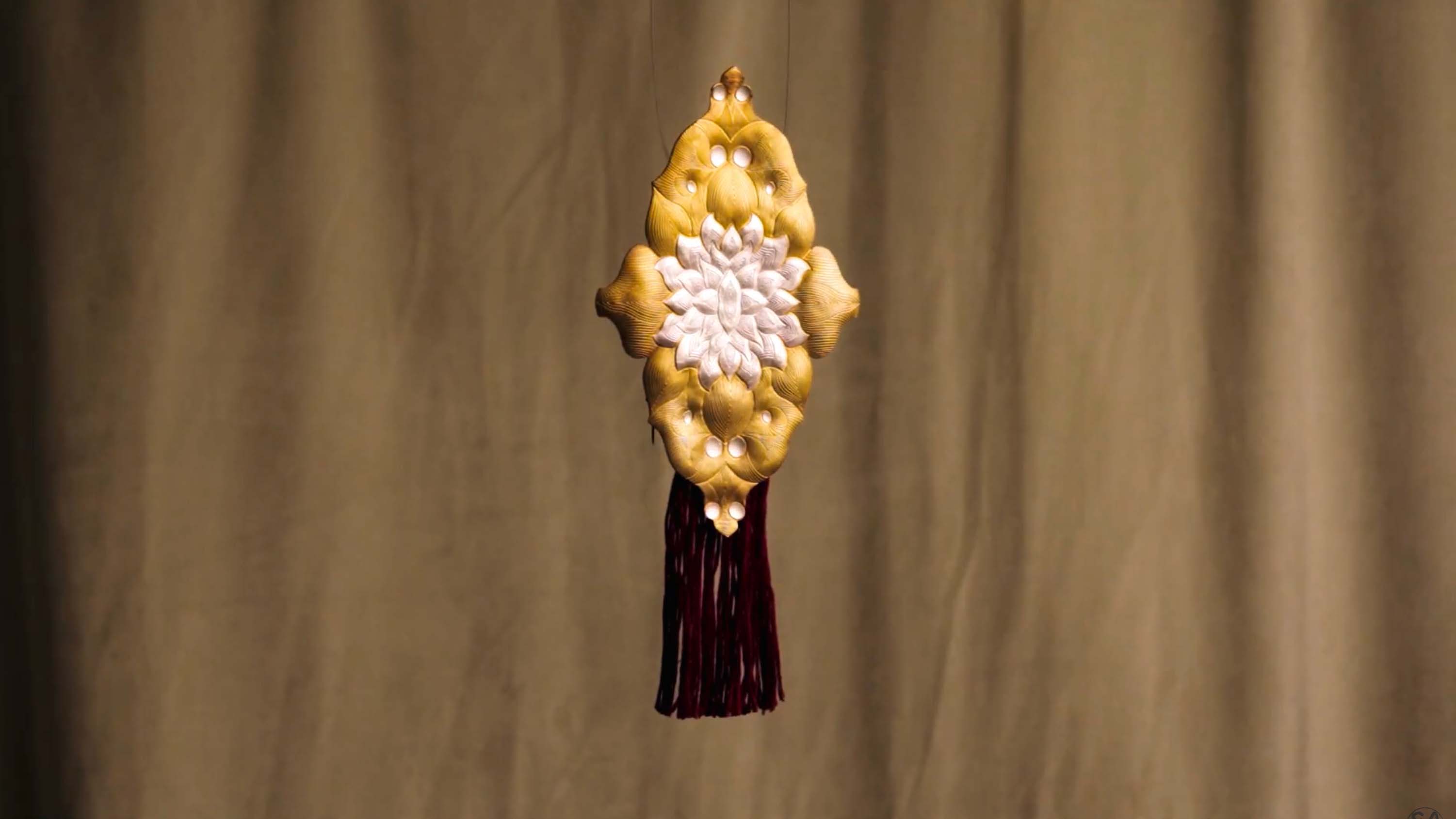 Dramatic close-up of a woman’s outstretched hand wearing bangles, illuminated against a dark background.