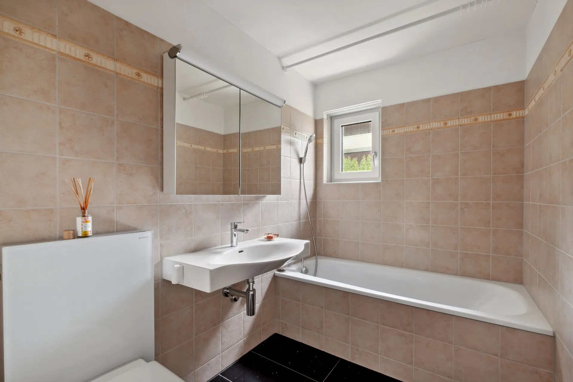Helles Badezimmer mit Badewanne, Tageslicht und Doppelspiegelschrank